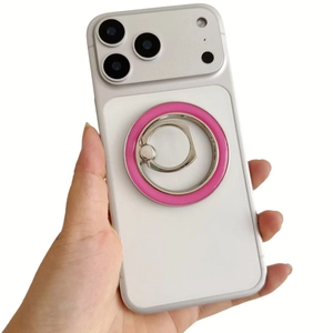 Detail of white smartphone case with pink metal magnetic ring stand held by a hand