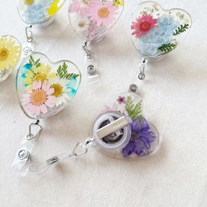 Heart-shaped retractable badge holder with real dried flowers and rotating metal clip