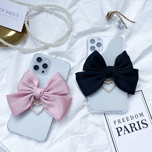 Cute iPhone cases featuring satin ribbons and heart pearl charms in pink and black