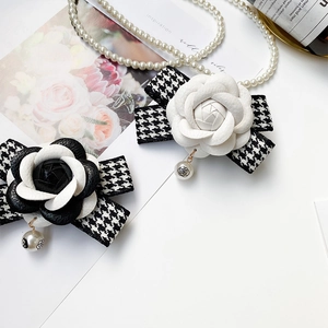 Support de téléphone camélia matelassé avec décoration de nœud en pied-de-poule noir et blanc