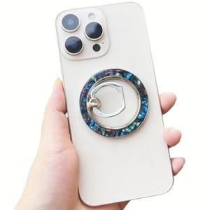Close-up of a foldable magnetic shell-pattern phone ring holder on a white smartphone