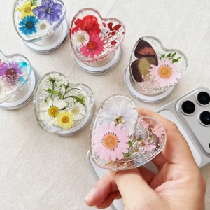 Detail of heart-shaped phone grip with real dried flowers and resin craftsmanship