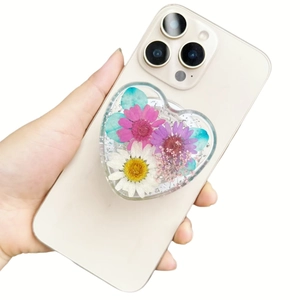 Handheld heart-shaped phone socket featuring real dried flowers and gold foil in clear resin