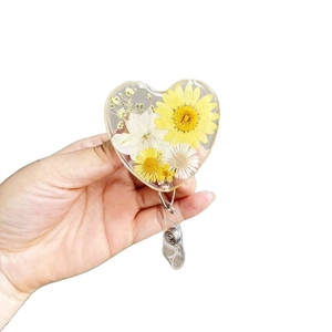 Retractable heart-shaped badge holder with real dried flowers in transparent resin