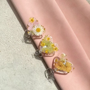 Heart-shaped badge reel with real pressed dried flowers and gold foil in clear resin