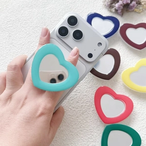 Multi-colored heart-shaped acrylic mirror phone socket stands displayed on white fabric