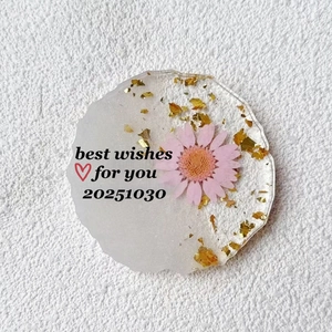 Handmade flower resin coaster with pink daisy and gold foil accents in petal shape