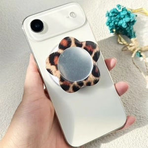 Macro detail of a leopard print flower magnetic phone grip and mirror on a white smartphone