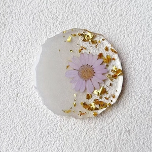 Detail of irregular resin coaster with purple dried flower and gold foil flakes