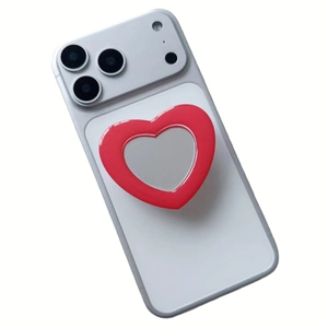 Detail of red heart phone grip with built-in mirror attached to a white mobile device