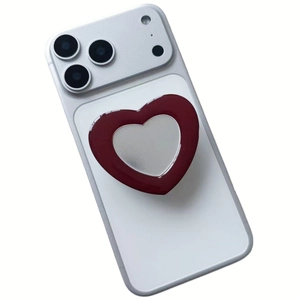 Macro detail of the heart-shaped phone grip with silver mirror and red acrylic frame