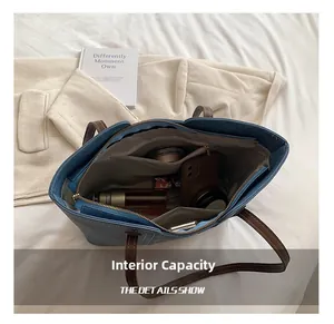 Internal view of a blue tote bag with brown handles showing multiple compartments and items