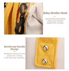 Detail of stroller hooks and reinforced handle stitching on a yellow diaper backpack