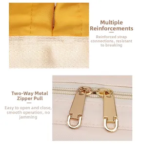 Detail of reinforced shoulder strap stitching and smooth two-way gold metal zippers on diaper bag
