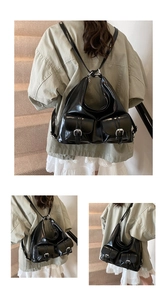 Detail of black glossy dual-pocket tote showing silver buckles and vintage style leather