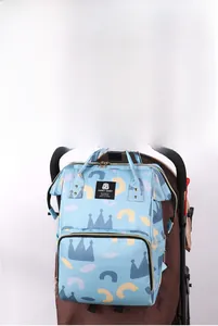 Detail of waterproof diaper bag with crown patterns hanging on a baby stroller handle