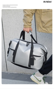 Macro detail of silver waterproof travel bag with reinforced black straps and multi-pockets