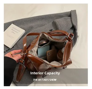 Detail of spacious interior in dark brown leather tote bag showing pockets and items