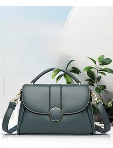 Detailed view of dark blue pebbled leather handbag with gold metal clasp and handle
