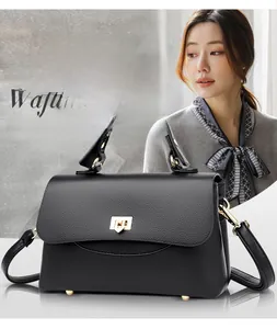 Macro shot of black lychee grain leather handbag with gold heart-shaped metal twist lock
