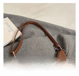Close-up of glossy brown patent leather shoulder bag with silver buckle and sleek handle