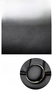 Detail of black litchi grain leather bag with polished gold hardware and durable texture