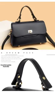 Detail view of premium black lychee leather handbag handle and gold metal twist lock closure