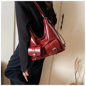 Detailed shot of dark red glossy patent leather tote with silver buckle front pockets