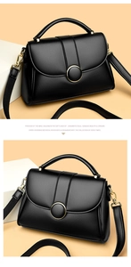 Close-up of litchi texture black leather handbag with a golden circular metal buckle