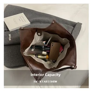 Spacious interior of dark brown tote bag with grey lining and functional compartments