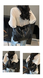 Détail du sac cabas noir texturé montrant la poche latérale et les larges bandoulières