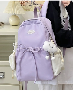 Detail of light purple nylon backpack showing side view, bow ribbon and cloud pendant charm