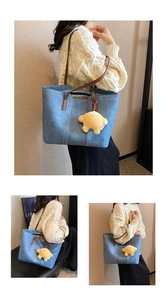 Blue denim tote bag with brown leather handles and star plush pendant detail