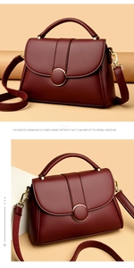 Close-up of wine red grainy leather texture and gold hardware on minimalist handbag