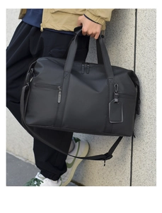 Close-up of the durable waterproof black fabric and reinforced handle on this travel bag