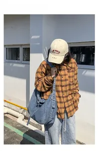 Outdoor shot of a blue denim tote bag paired with a yellow plaid flannel shirt
