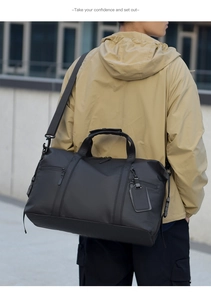 Man carrying a black large capacity travel bag with shoulder strap in outdoor setting