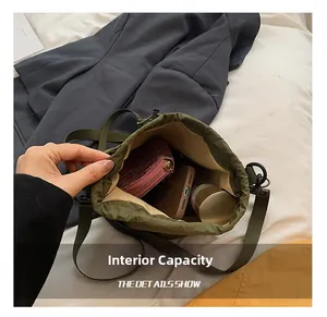 Detail view of large interior capacity of green drawstring nylon bucket bag with items