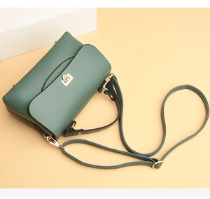 Detail showing high-quality lychee texture leather and golden metal square buckle on bag