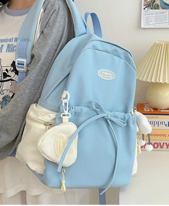 Detail shot of blue school backpack with bow drawstring and mini heart pouch on side