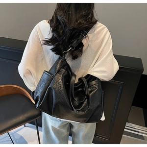 Détail du sac cabas en cuir grainé noir avec fermeture éclair latérale et large bandoulière