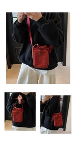 Détail du mini sac à bandoulière rouge avec fermeture à cordon et poche zippée avant