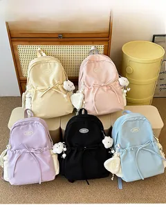 Row of colorful school backpacks with cute plush cloud charms and ribbon bow details