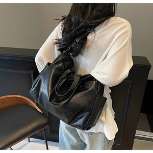 Détail d'un grand sac cabas noir avec texture litchi souple et poche latérale pratique