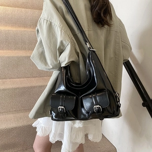 Glossy black hobo bag with front pockets and silver buckles for casual styling