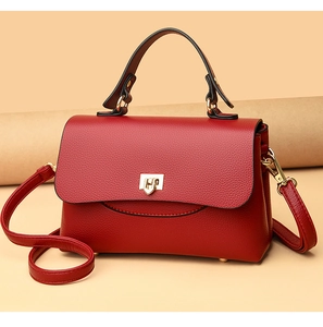 Detail of red litchi texture leather handbag with gold hardware and top handle