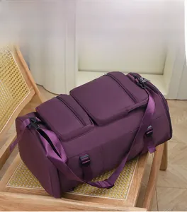 Détails d'un sac de sport violet avec plusieurs fermetures éclair et bandoulière réglable