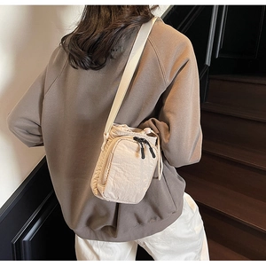 Vue détaillée d'un sac bandoulière beige imperméable pour gourde avec fermeture à cordon