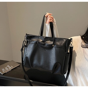 Détail du sac cabas noir texture litchi avec rivets métalliques et poche latérale