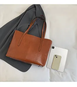 Top view of brown vintage tote bag showing interior space and size compared to tablet